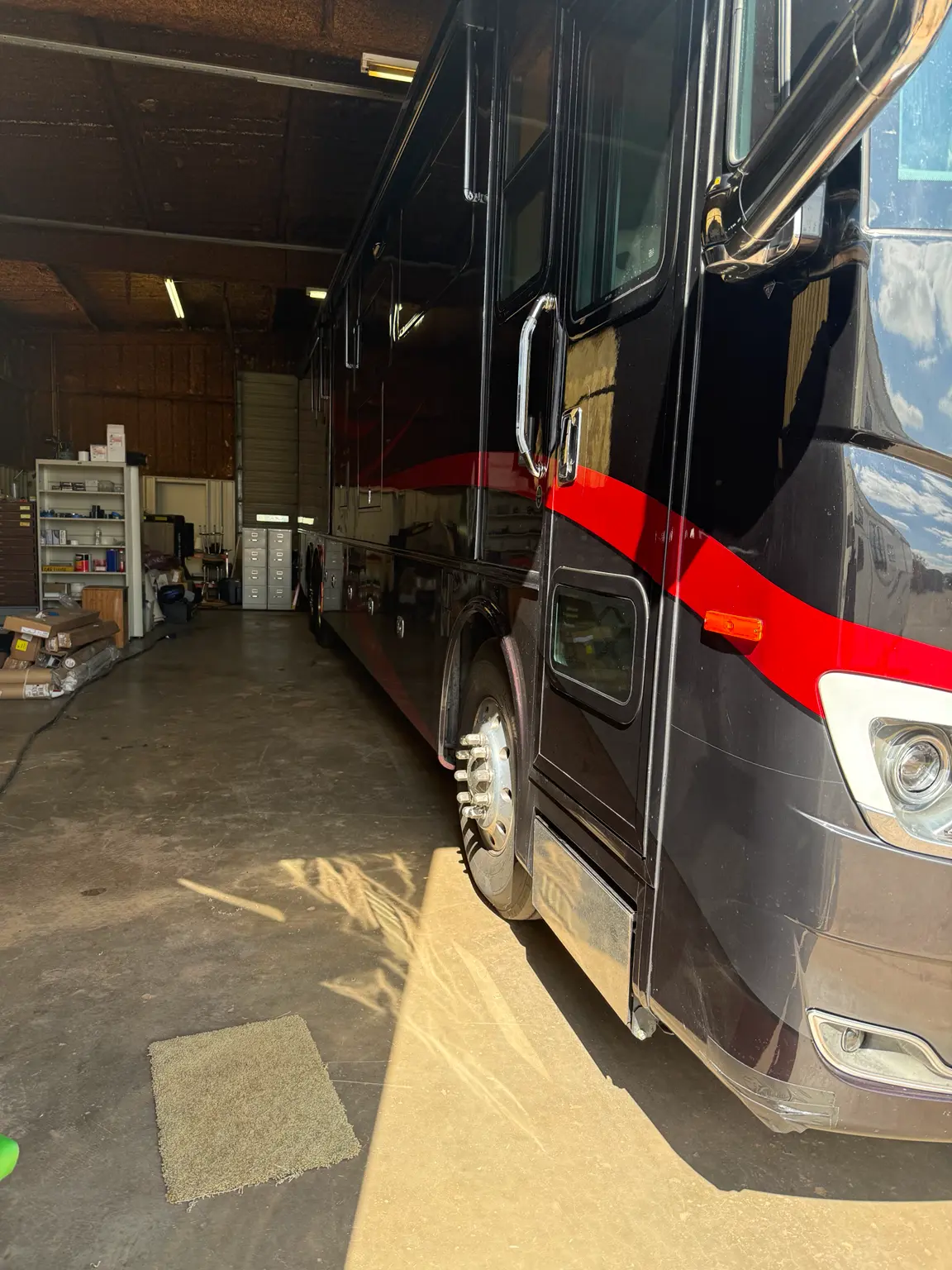 Front corner view of a motorcoach inside the Elk City RV Service shop